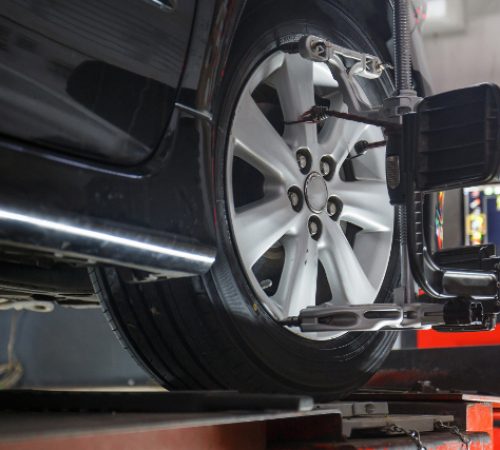 Car on stand with sensors on wheels for wheels alignment camber check in workshop of Service station.