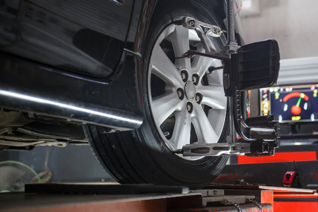 Car on stand with sensors on wheels for wheels alignment camber check in workshop of Service station.